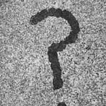 Black question mark stain on a gray concrete surface.
