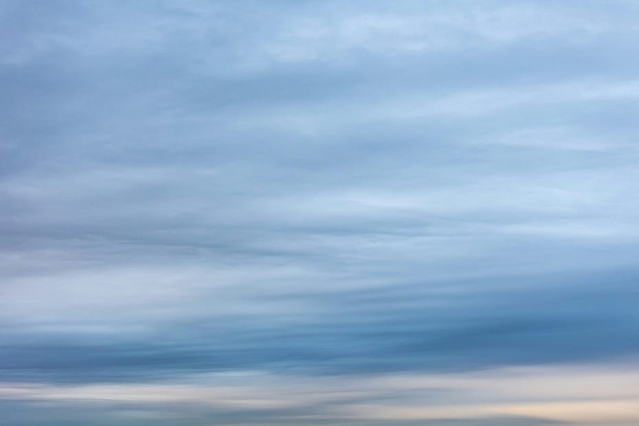 a couple of people standing on top of a sandy beach